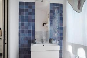 a bathroom with a sink and a blue tiled wall at Rosadimaggio Violetta in Arcola