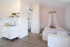 a white bedroom with a bed and a sink at Rosadimaggio Violetta in Arcola