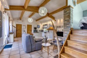 a living room with wooden ceilings and a staircase at Les Bois flottés in Poussan