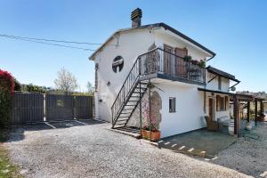 a white house with a balcony and a fence at Rosadimaggio Violetta in Arcola
