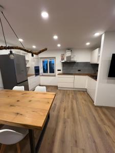 a kitchen with a wooden table and white cabinets at Ferienwohnung Am Biohof in Mengkofen +13 photos