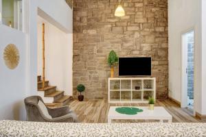 a living room with a tv and a brick wall at Funchal Boa Nova Apartment in Funchal