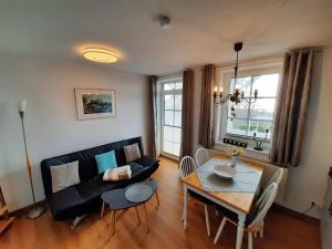 a living room with a black couch and a table at Villa Bella Vista - Meerblick 2 in Sassnitz