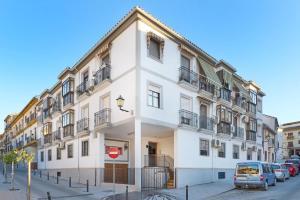 a white building with cars parked in front of it at Casa Curro en Baena in Baena