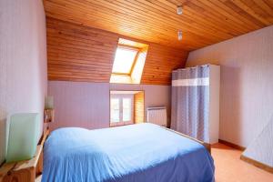 a bedroom with a large bed with a wooden ceiling at Gite Tikilou 6 Pers proche montagne in La Tour-dʼAuvergne