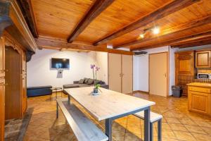 a kitchen and living room with a wooden ceiling at Gite Tikilou 6 Pers proche montagne in La Tour-dʼAuvergne