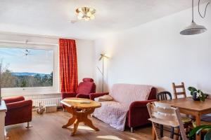 a living room with a couch and a table and a window at Wohnung Fuchsenstein-Foxy in Spiegelau