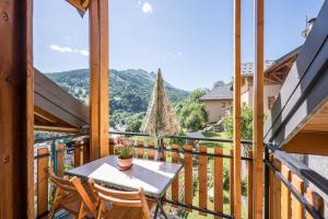 a table and chairs on a balcony with a view at La Mouliniere 1 in Valloire