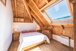 a bedroom with a bed and a large window at La Mouliniere 1 in Valloire