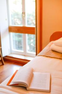 an open book sitting on a bed with a window at Bahia Sea View Apartment in Caminha