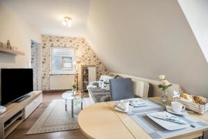 a living room with a table and a tv at Kleiner Priel in Dorum