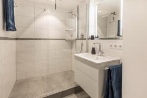 a white bathroom with a sink and a shower at Heidis Dihei in Büsingen +18 photos