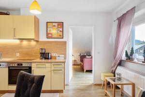a kitchen with yellow cabinets and a table in a room at Ferienwohnung Eulennestle in Lenzkirch +15 photos