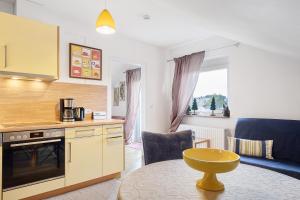 a kitchen with a table and a living room at Ferienwohnung Eulennestle in Lenzkirch