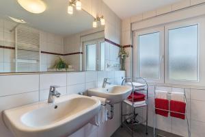 a bathroom with two sinks and a mirror at Ferienwohnung Smithson in Biberach +43 photos