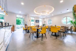 a dining room with yellow chairs and tables at PrimeStayBudapest in Budapest