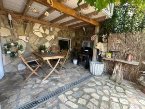 a patio with a wooden table and a stone wall at Ferienwohnung Insel Reichenau in Rheinstraße