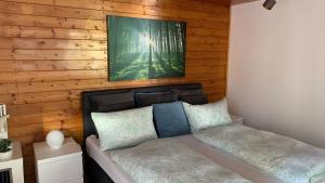 a bed in a room with a wooden wall at Ferienhaus mit Sauna am Waldrand in Friedrichroda