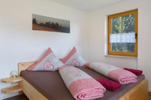 a couch with pillows on it in a room at Hinterbauernhof Fewo Kuhgeflüster in Stegen