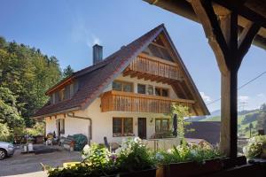 a house with a gambrel roof with a patio at Hinterbauernhof Fewo Kuhgeflüster in Stegen