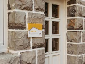 a building with a sign on a stone wall at Ferienwohnung Wennetal in Schmallenberg