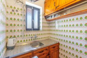a kitchen with a sink and green and white tiles at Mires House Apartment 11 in Agios Gordios +24 photos
