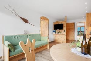 a living room with a green couch and a table at Pfösslerhof in Bolzano
