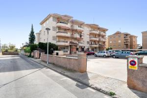 a building with cars parked in a parking lot at Apartamentos Cunidor - Cunit in Cunit