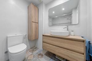 a bathroom with a toilet and a sink and a mirror at Apartamentos Cunidor - Cunit in Cunit +17 photos