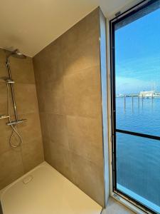 a bathroom with a shower and a large window at Floating Home Nr 1a in Laboe +32 photos
