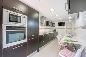 a kitchen with stainless steel appliances and a table at Villa Alma Azul in Llucmajor