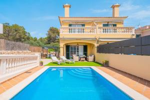 a villa with a swimming pool in front of a house at Villa Alma Azul in Llucmajor