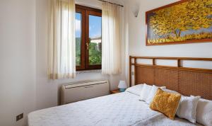 a bedroom with a white bed and a window at Villa Mistral in Costa Rei