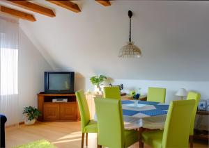 a dining room with a table and green chairs at Haus Wehrle in Breisach am Rhein