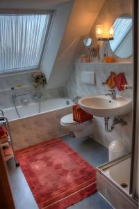 a bathroom with a tub and a sink and a toilet at Haus Wehrle in Breisach am Rhein +6 photos