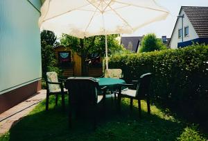 a table and chairs under an umbrella in a yard at Haus Wehrle in Breisach am Rhein