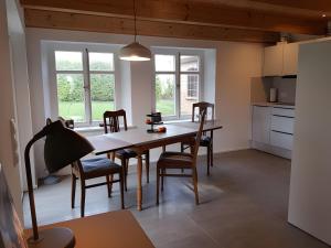 a kitchen and dining room with a table and chairs at Schäferhaus in Hemme +18 photos
