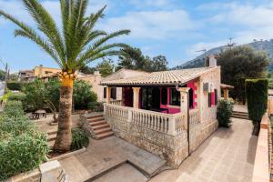 a pink house with a palm tree in front of it at Casa Isabel y Mateo in Cala de Sant Vicenc