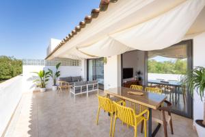 a patio with a wooden table and yellow chairs at Golf Beach Vera in Vera