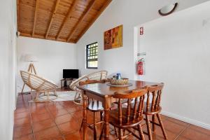 a dining room with a wooden table and chairs at Casa Ponta do Biscoito in Lajes do Pico