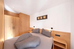 a bedroom with a bed and wooden cabinets at Thalerhof Sancta Sebastianus in Auna di Sotto