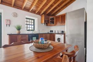 a kitchen with a wooden table with a bowl on it at Casa Ponta do Biscoito in Lajes do Pico