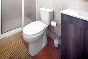 a bathroom with a white toilet and a sink at Casa Ponta do Biscoito in Lajes do Pico +13 photos