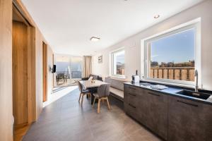 a kitchen with a table and a large window at Thalerhof Sancta Sebastianus in Auna di Sotto