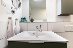 a bathroom with a white sink and a mirror at Gosewatt Wohnung 4 in Husby +13 photos