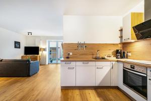 a kitchen with white cabinets and a living room at Gosewatt Wohnung 4 in Husby