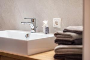 a bathroom with a sink and towels on a counter at Mittnackerhof Apartment Melisse in Sarntal +21 photos