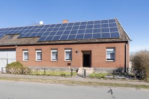 a brick house with solar panels on the roof at Ferienwohnung Ruhezone in Gardelegen
