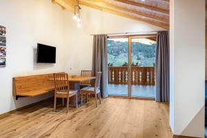 a dining room with a table and chairs and a window at Mittnackerhof Apartment Melisse in Sarntal