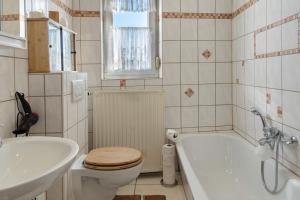 a bathroom with a toilet and a tub and a sink at Ferienwohnung Ruhezone in Gardelegen +17 photos